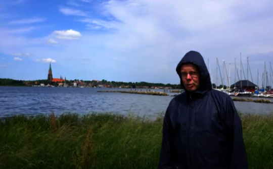 Pastor Hansen vor der Schlei mit dem Schleswiger Dom